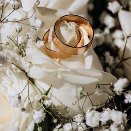 Golden wedding rings on the white rose  from the wedding bouquet